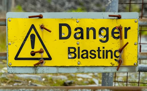 Blasting danger sign near gravel quarry pit similar to the planned Vulcan Comal Quarry between Bulverde and New Braunfels