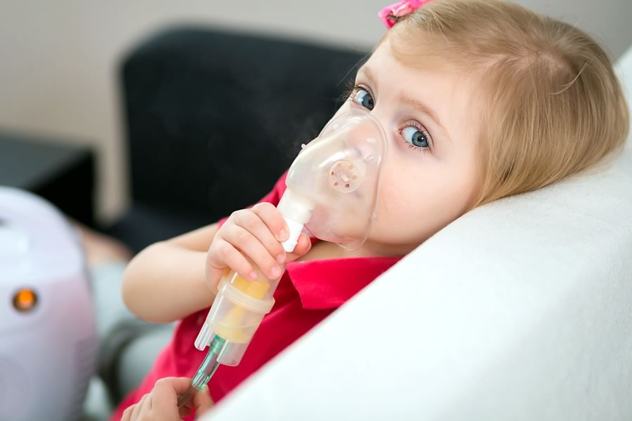 Girl with nebulizer suffering from breathing problems